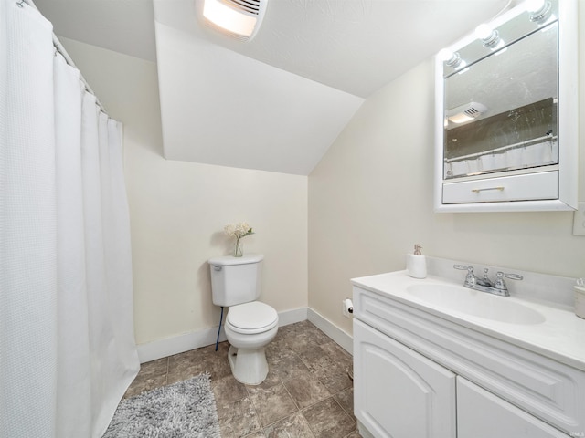 bathroom with vanity, toilet, and lofted ceiling