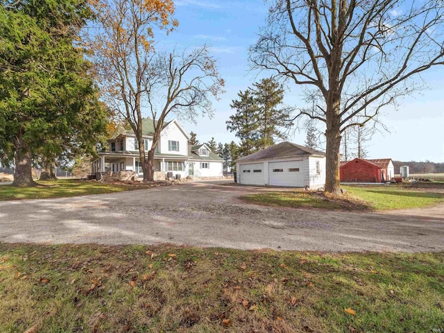 view of front facade featuring a garage, an outbuilding, and a front lawn