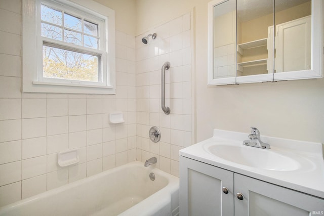 bathroom with tiled shower / bath combo and vanity