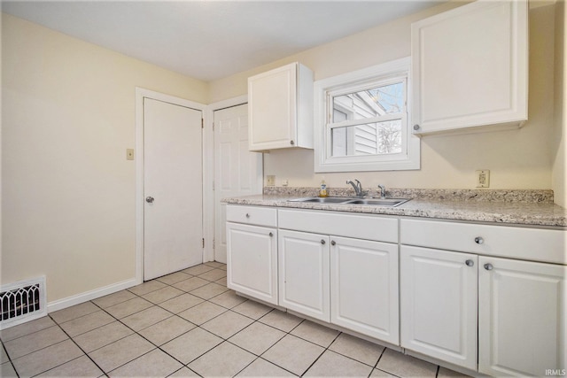 kitchen with sink, white cabinets, and light tile patterned flooring