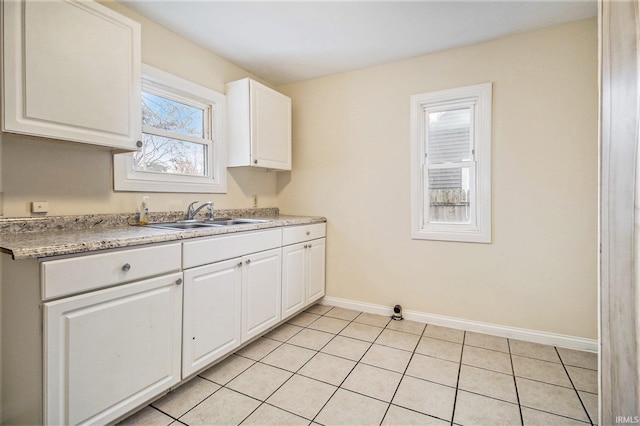 kitchen with sink, white cabinetry, light tile patterned floors, and plenty of natural light