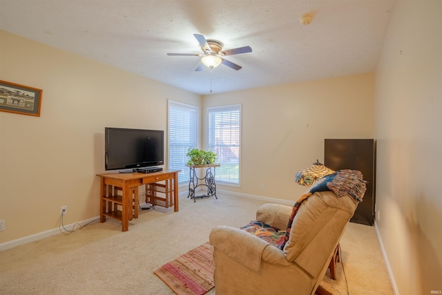 living room with a textured ceiling, light colored carpet, and ceiling fan