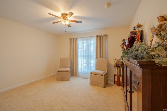 sitting room with ceiling fan and light colored carpet