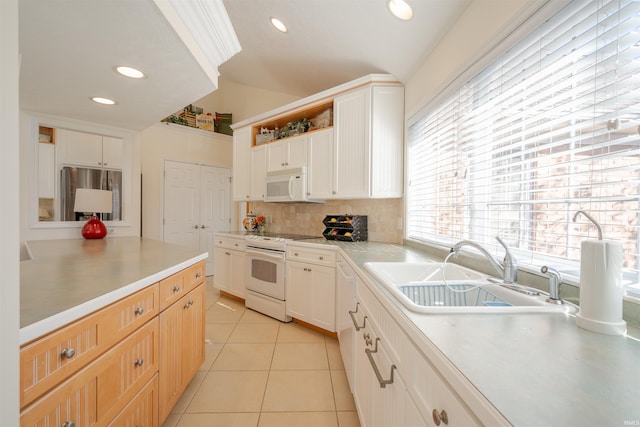 kitchen featuring sink, light tile patterned flooring, white appliances, decorative backsplash, and white cabinets