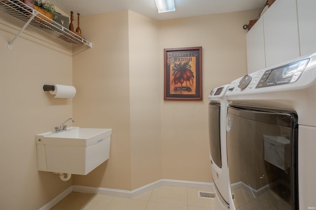 washroom featuring washer and dryer, light tile patterned floors, and sink