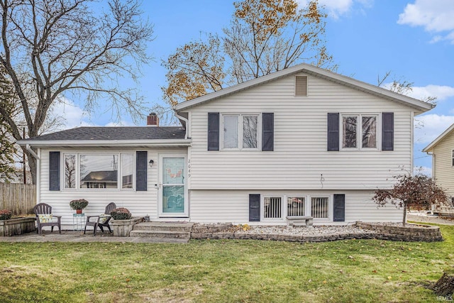 back of property with a yard and a patio