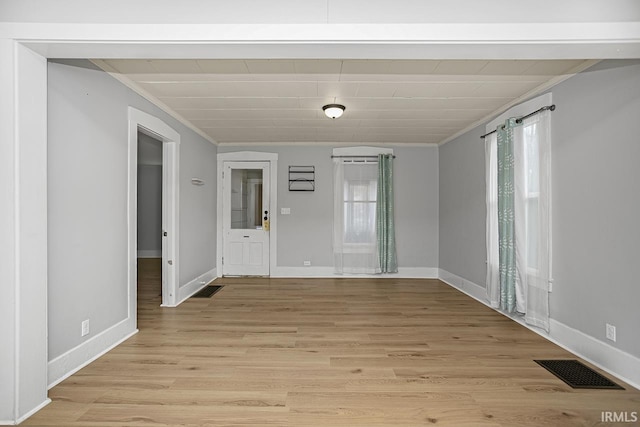 empty room with light hardwood / wood-style floors and ornamental molding