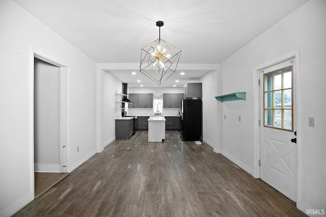 kitchen featuring extractor fan, decorative light fixtures, a notable chandelier, dark hardwood / wood-style floors, and fridge