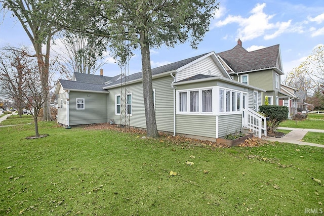 view of home's exterior with a lawn and a sunroom