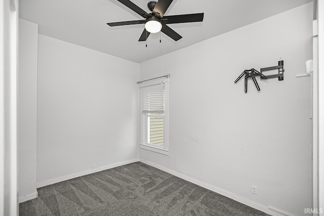 spare room with dark carpet and ceiling fan