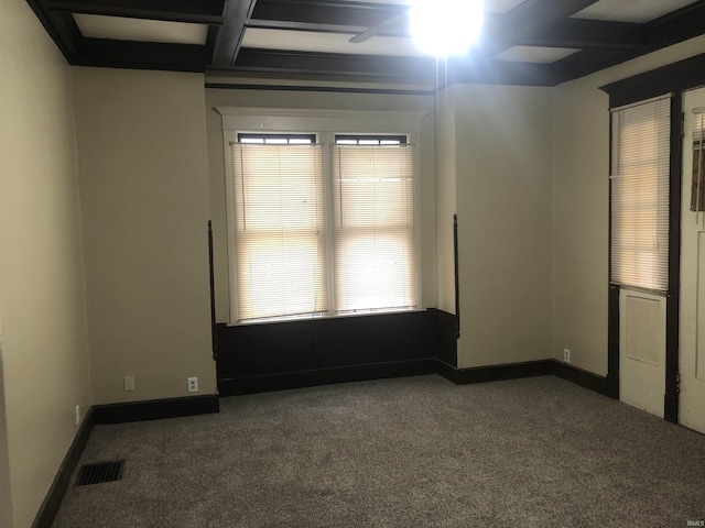 unfurnished room with beamed ceiling, dark colored carpet, ceiling fan, and coffered ceiling