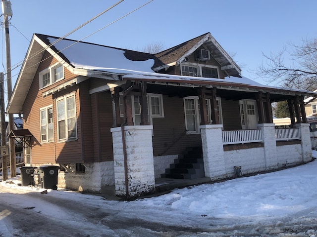 view of snowy exterior with covered porch