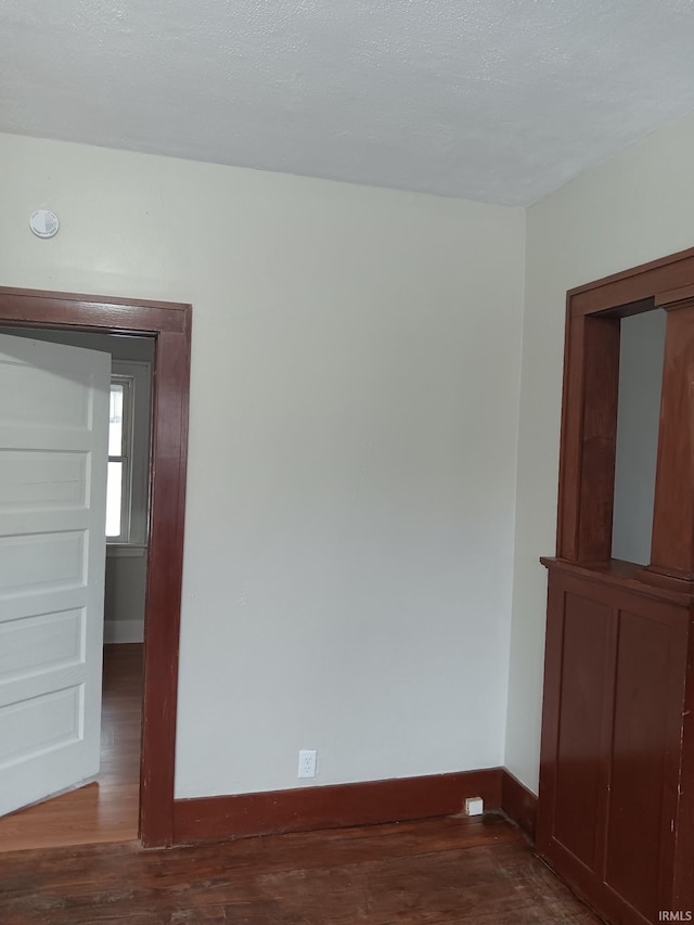 unfurnished room featuring dark wood-type flooring