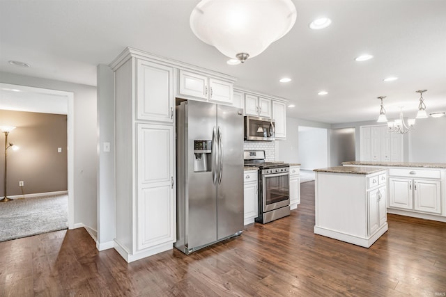 kitchen with appliances with stainless steel finishes, a center island, dark hardwood / wood-style floors, and white cabinetry