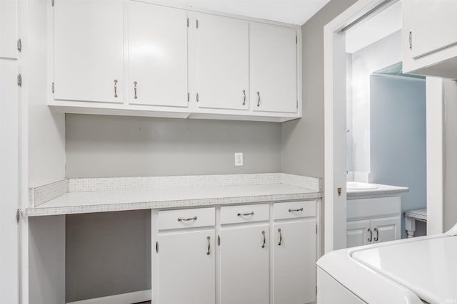 clothes washing area featuring cabinets