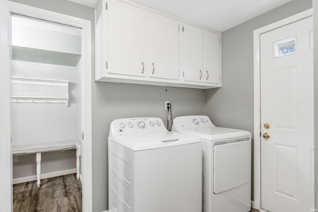 laundry area featuring cabinets, dark wood-type flooring, and washer and dryer