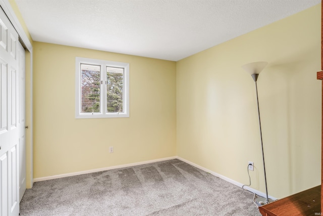 unfurnished bedroom with carpet floors, a textured ceiling, and a closet