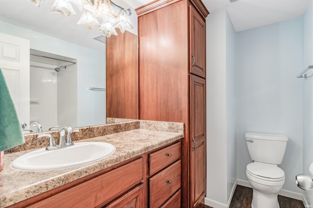 bathroom featuring vanity, wood-type flooring, and toilet