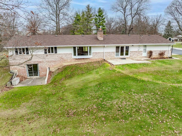 back of property featuring a patio area and a yard