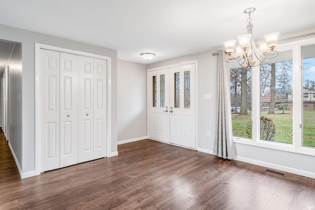 foyer featuring a notable chandelier and dark hardwood / wood-style flooring