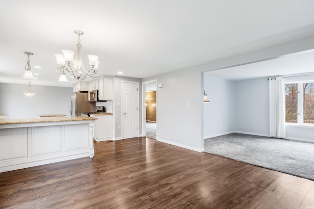 kitchen featuring dark hardwood / wood-style floors, a notable chandelier, decorative light fixtures, white cabinets, and appliances with stainless steel finishes