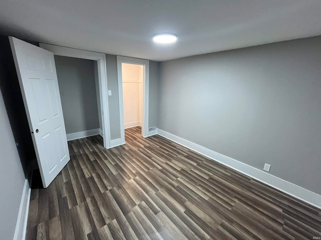 unfurnished bedroom with a closet and dark hardwood / wood-style flooring