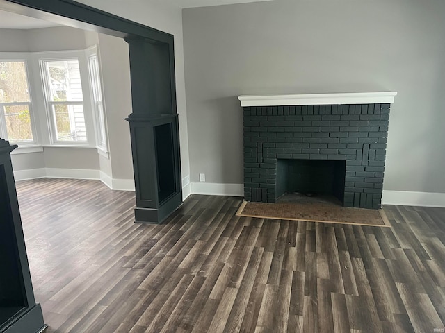 unfurnished living room featuring a fireplace and dark hardwood / wood-style floors