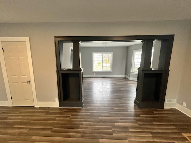 unfurnished living room with dark hardwood / wood-style flooring and a chandelier