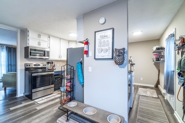 kitchen featuring baseboard heating, dark hardwood / wood-style flooring, white cabinets, and appliances with stainless steel finishes