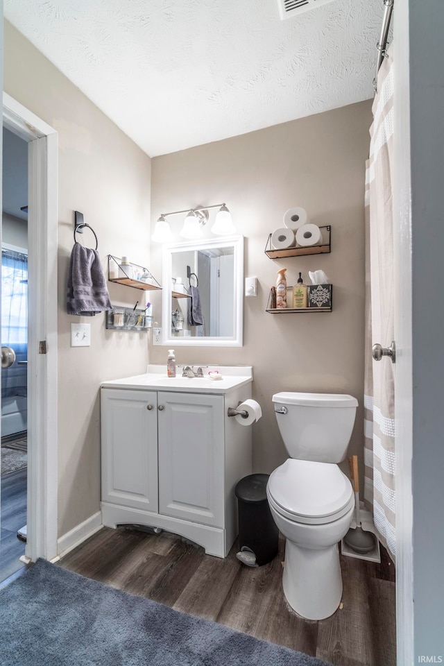 bathroom featuring hardwood / wood-style floors, vanity, a textured ceiling, and toilet