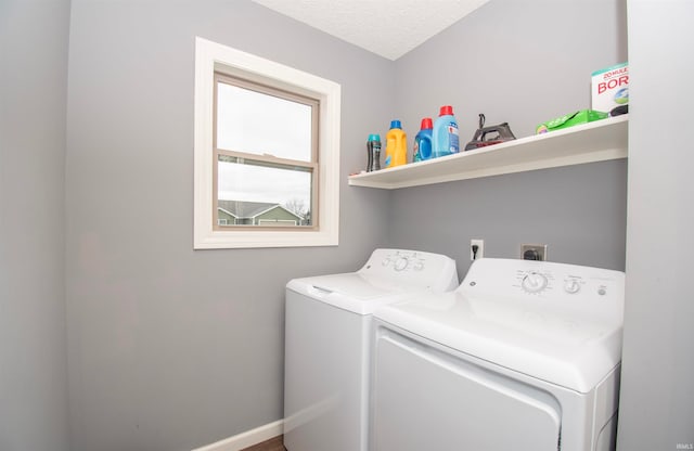 washroom with a textured ceiling and separate washer and dryer