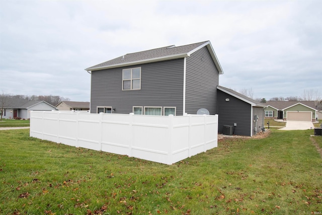 rear view of house with a yard and cooling unit