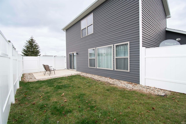 rear view of property with a lawn and a patio