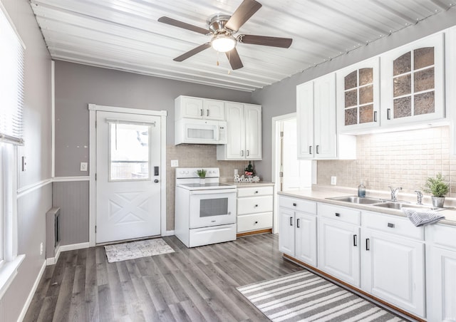 kitchen featuring white appliances, wood-type flooring, sink, decorative backsplash, and white cabinetry