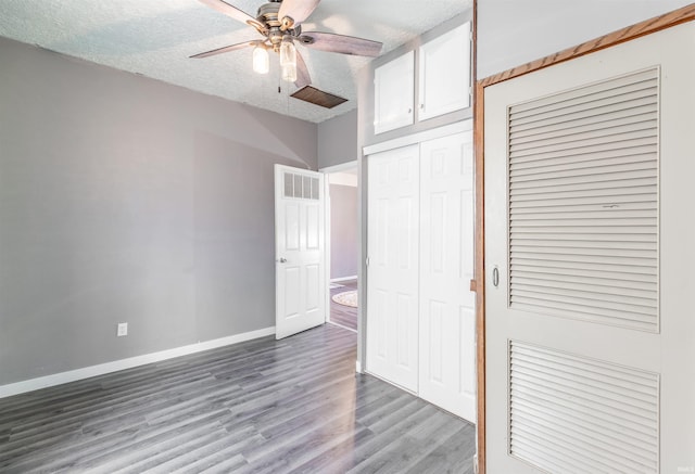 unfurnished bedroom with ceiling fan, a textured ceiling, and light wood-type flooring