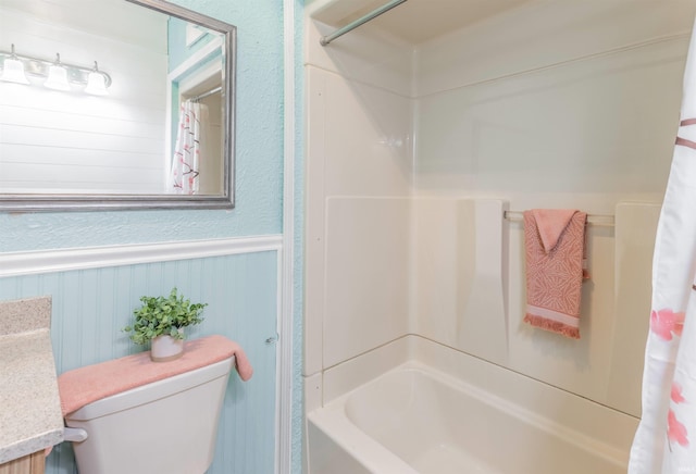 bathroom with shower / tub combo with curtain and toilet