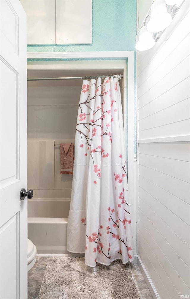 bathroom with shower / tub combo with curtain and toilet