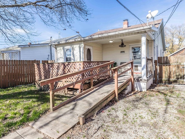 back of property featuring a lawn and a deck