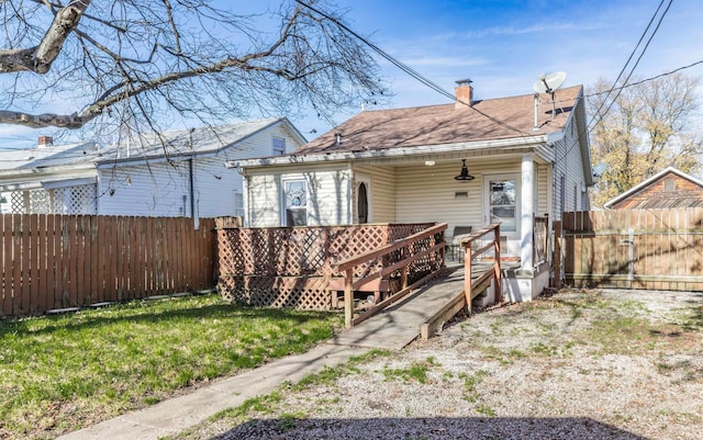 back of property featuring a lawn and a deck