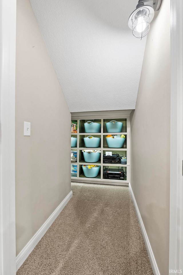 interior space with carpet flooring, a textured ceiling, and vaulted ceiling