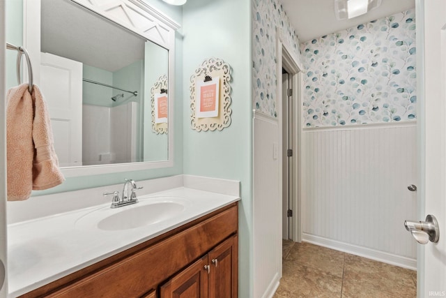 bathroom with a shower, tile patterned flooring, and vanity