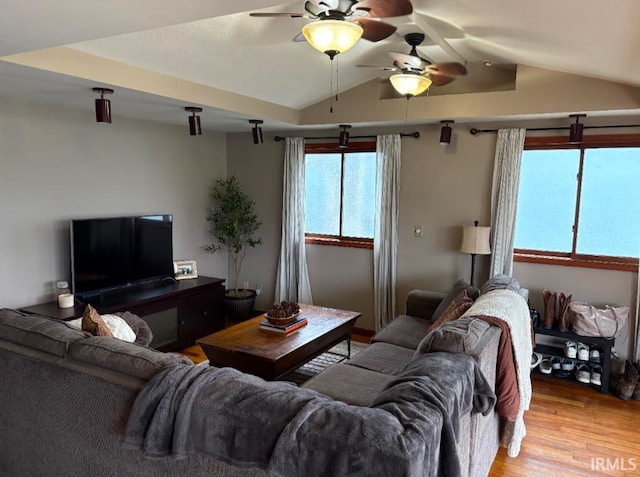 living room featuring ceiling fan, light hardwood / wood-style flooring, and lofted ceiling