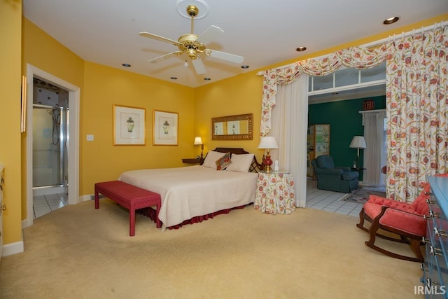 carpeted bedroom with ensuite bathroom and ceiling fan