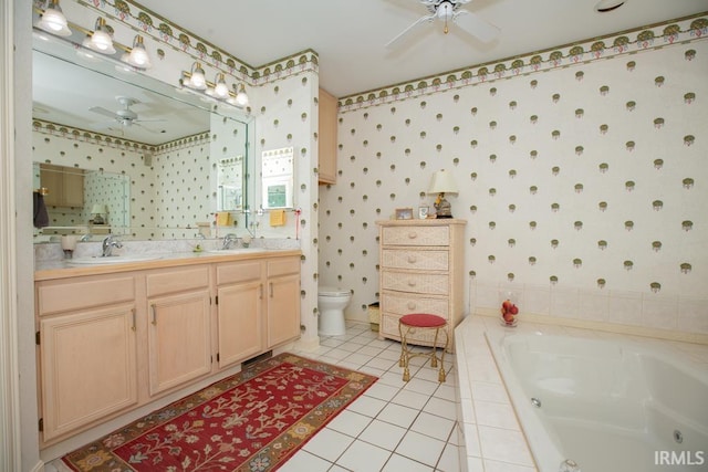 bathroom with vanity, tile patterned flooring, a relaxing tiled tub, and toilet