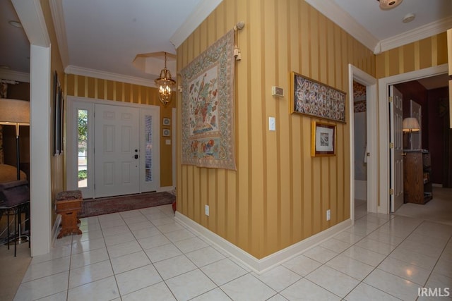 tiled foyer with ornamental molding and a chandelier