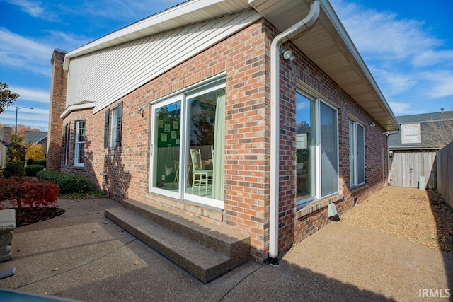 view of side of home with a patio area and a shed