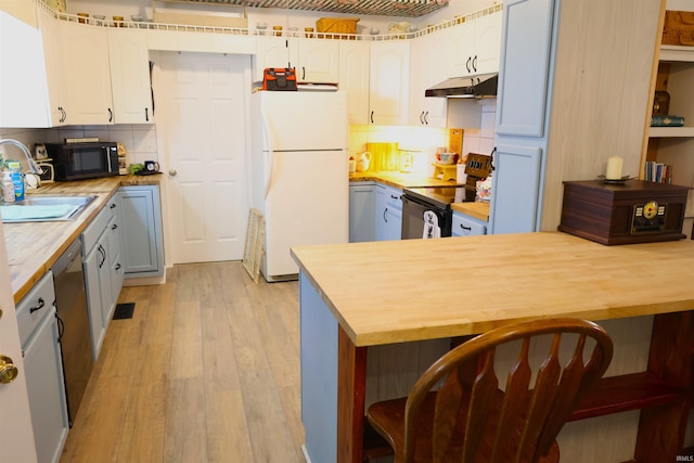 kitchen featuring sink, black appliances, light hardwood / wood-style flooring, white cabinets, and butcher block countertops