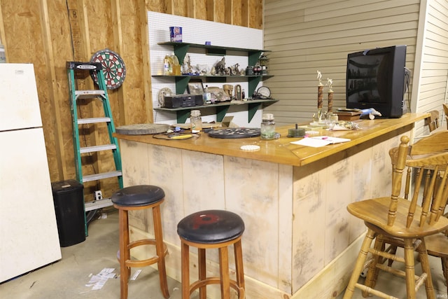 bar featuring white refrigerator and wooden counters