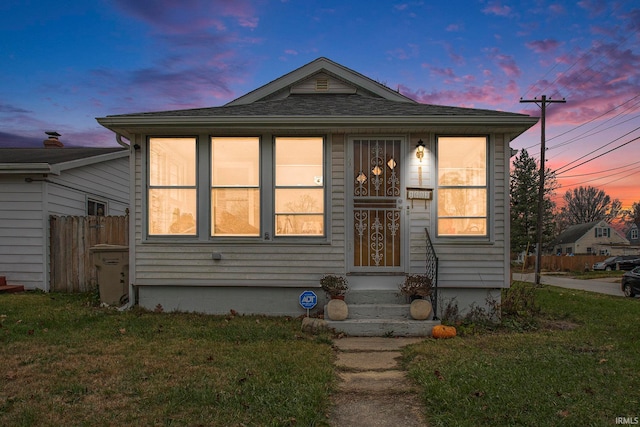 bungalow with a front yard and fence