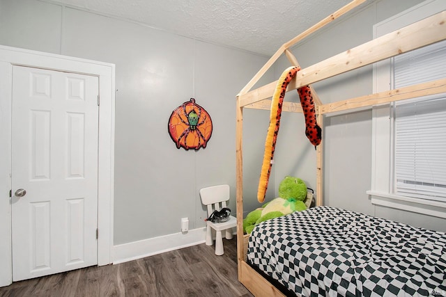 bedroom featuring a closet, dark wood-type flooring, and a textured ceiling